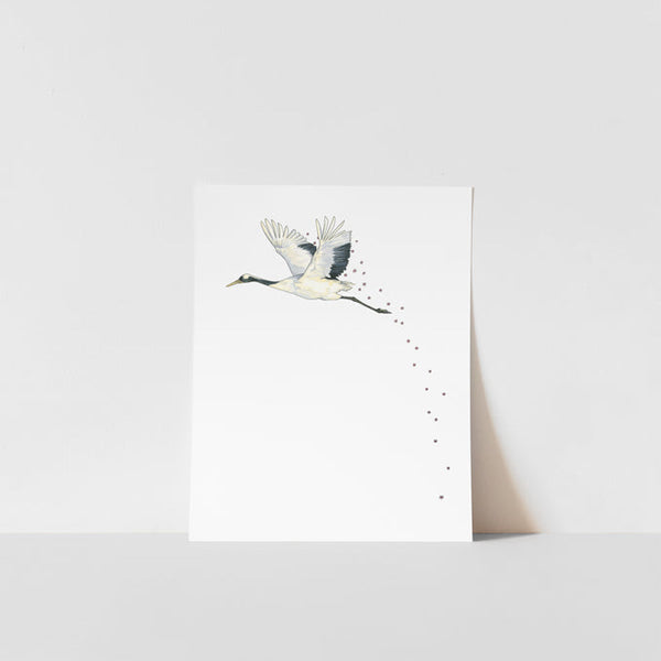 A art print of a Japanese crane with a blossom in its beak, printed on ultra premium matte paper with archival inks, signed by Heather S Vitticore.
